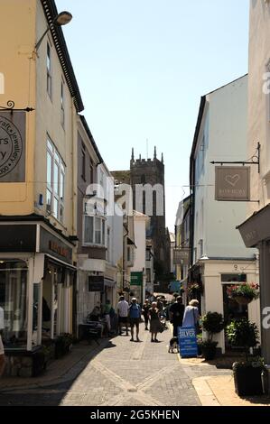 The shops along Foss Street in the Devon town of Dartmouth with the church of St Saviour's in the background. Stock Photo