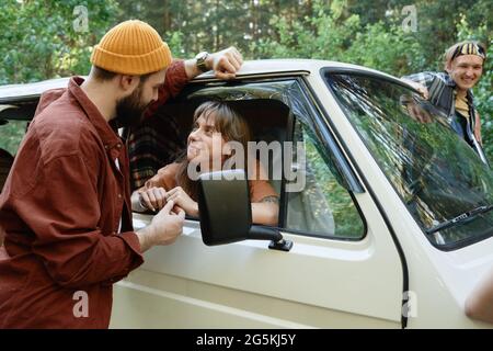 Young man talking to woman who sitting in the car he asking the way Stock Photo