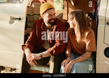 Young couple sitting in the bus and talking to each other they spending time outdoors Stock Photo