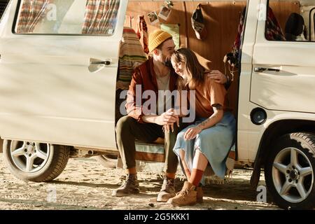 Young couple sitting in the van and embracing each other they enjoying their vacations Stock Photo