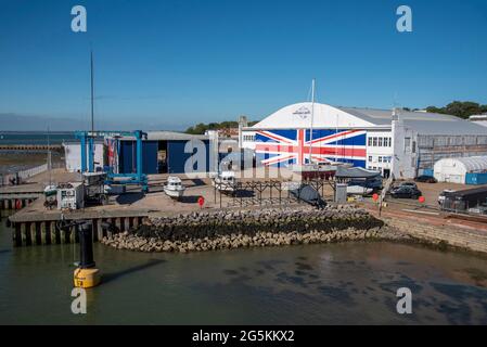 East Cowes, Isle of Wight, England, UK. 2021.  Boatyard in East Cowes with sliding doors painted as a Union Jack on the waterfront. Stock Photo