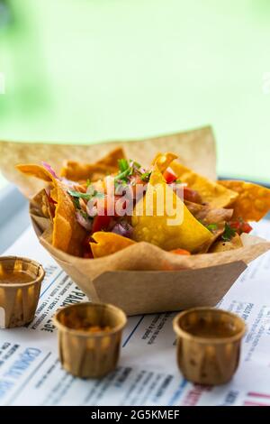 Nachos salsa in a street cafe on a paper plate with sauces. Traditional  Mexican dish Stock Photo - Alamy