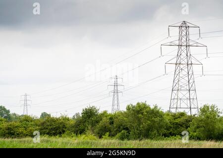 Electricity pylons carrying cables across landscape at Portbury Wharf Nature Reserve, Portishead, Somerset, UK. Stock Photo
