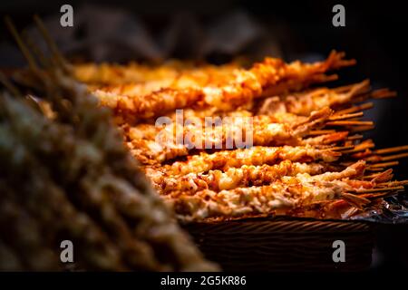 Kyoto, Japan grilled shrimp fried skewers seafood food snack on sale display in Nishiki market street Stock Photo