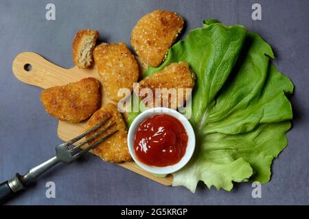 Meat substitute on wooden board and tray with ketchup, imitation meat, Germany, Europe Stock Photo