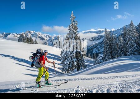 Ski tourers in front of snowy landscape, ski tour to the Alpspitze, Wetterstein mountains with snow in winter, Garmisch-Partenkirchen, Bavaria, German Stock Photo