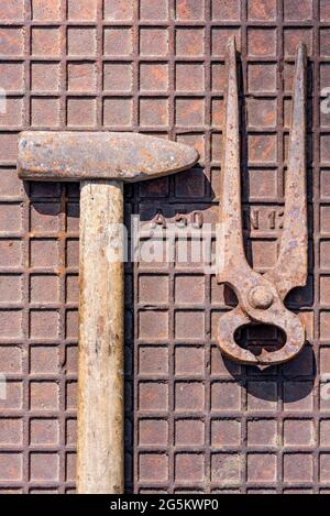 Old hammer with pincers or biting pliers, rusty tool on rusty iron plate, Germany, Europe Stock Photo
