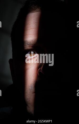 man portrait hiding in the shadows Stock Photo