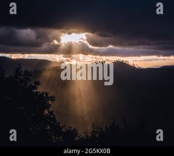 Sunlight rays burst through clouds after storm, Yosemite California Stock Photo