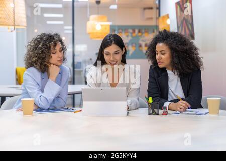 business women having a reunion in the office and using digital tablet. Stock Photo