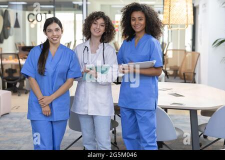 Young female medical work team wearing work uniform smiling and looking at camera. Stock Photo