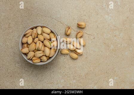 Pistachio top view. Pistachios in a saucer on a marble stone table top. Banner for website header, design or print. Stock Photo