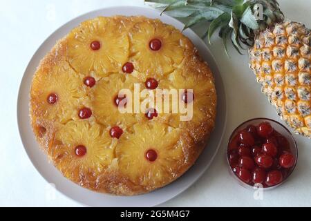 Caramelised pineapple upside down cake. Home baked pineapple cake with pineapple slices are on the top. Shot on white background Stock Photo