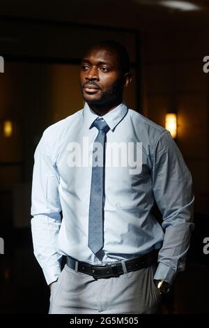 Vertical portrait of handsome African-American businessman looking away in sunlight Stock Photo