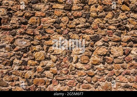 Stone wall showing red iron content and texture - Mezieres-en-Brenne, Indre (36), France. Stock Photo