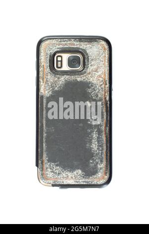 Mobile smartphone with camera in a used Old and dirty plastic case. Backside top view isolated on white Stock Photo
