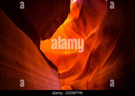 Looking up on upper Antelope slot canyon with red orange bright colorful layers of wave shape rock sandstone in Page, Arizona abstract background Stock Photo