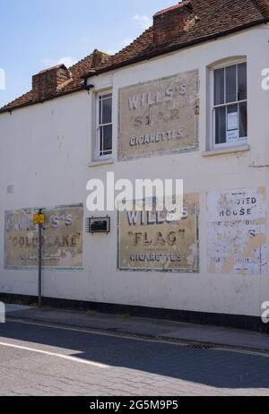 Old and peeling painted Wills's cigarette advertisements on the wall of a building. Whitstable, Kent, England, UK Stock Photo
