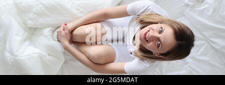 Young woman in pajamas in bed top view Stock Photo
