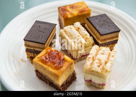Bite size French cake slices closeup with coffee opera, raspberry and chocolate pastry storebought in France handmade Stock Photo