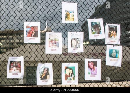 Surfside, Florida, USA. 25th June, 2021. Missing People signs hang on a fence by the collapsed condo in Surfside. Credit: Orit Ben-Ezzer/ZUMA Wire/Alamy Live News Stock Photo