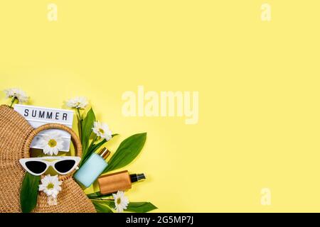 beach bag with beach accessories on a colored background top view. Sunscreen, glasses. Stock Photo