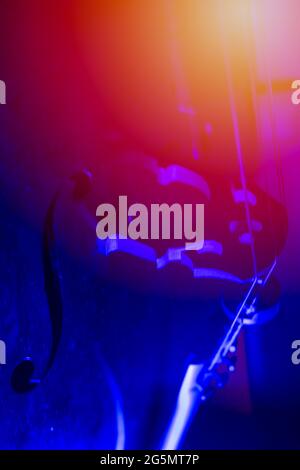 blue red and yellow neon lights on a cello as an artistic photo of a musical instrument concept. Stock Photo