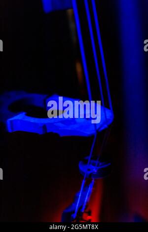 selective focus of the strings and the bridge of a cello with a mute with red and blue neon lights concept musical instrument artistic photo Stock Photo