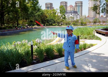 A boy dressed in a replica uniform of Red Army poses with a Chinese flag outside the Memorial of the First National Congress of the Communist Party of China, ahead of the 100th founding anniversary of the party, in Shanghai, China June 22, 2021. Picture taken June 22, 2021. REUTERS/Aly Song