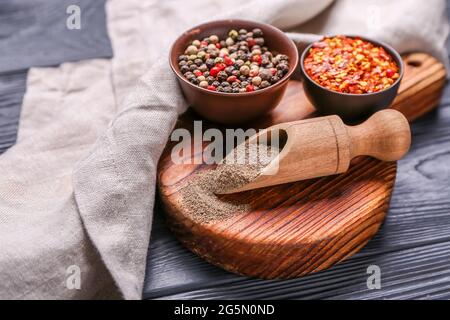 Board with different types of pepper on dark wooden background Stock Photo