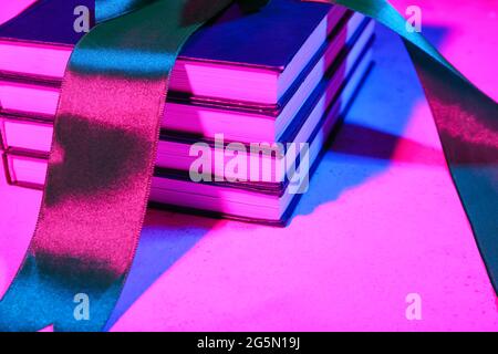 Stack of books with ribbon on dark color background, closeup Stock Photo