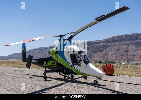 A Kaman K-Max K-1200 firefighting helicopter preparing to take off to fight a wildfire in Utah.  In the background is a 700 gallon external water heli Stock Photo