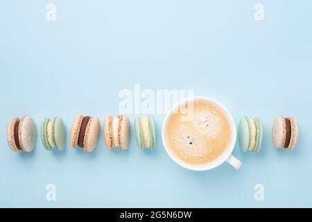 Creative flat lay. Cup of coffee, various macarons on blue background. Copy space for your text - Image Stock Photo