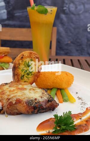 Roasted chicken fillet with Parmesan cheese, lemon juice, chicken spring rolls, and herbs. Stock Photo