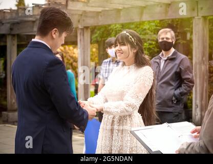 Biracial ride groom holding hands during outdoor wedding ceremony Stock Photo