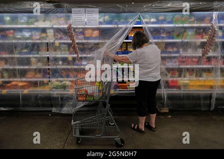 Portland, USA. 28th June, 2021. A woman shops for perishable items covered with a layer of plastic to keep in the cool air at a Fred Meyer grocery store in Portland, Ore., on June 28, 2021, where temperatures reached an all time high of 116 degrees Fahrenheit. (Photo by Alex Milan Tracy/Sipa USA) Credit: Sipa USA/Alamy Live News Stock Photo