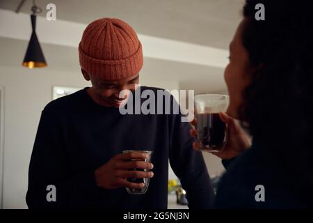 Mixed race couple drinking coffee together. Young, happy African American male smiling at his female partner. High quality photo Stock Photo