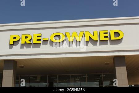 Yellow Pre-owned Sign on Car Dealership Stock Photo