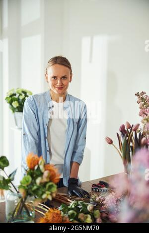 Smiling florist posing for the camera in a floral shop Stock Photo