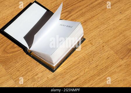 Open Holy Bible on a brown wooden table.Open Holy Bible top view.Religious concept. Stock Photo