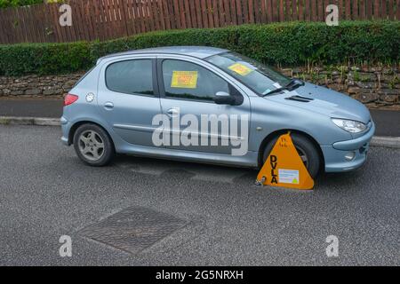 Car on road clamped for being untaxed by DVLA Stock Photo