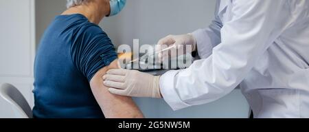 Senior woman being vaccinated against coronavirus Stock Photo