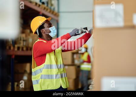 Black male worker scanning boxes in warehouse Stock Photo