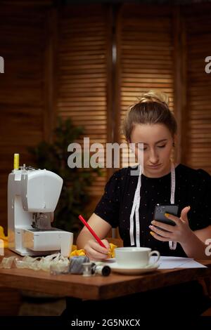 Beautiful young seamstress working on sewing machine Stock Photo