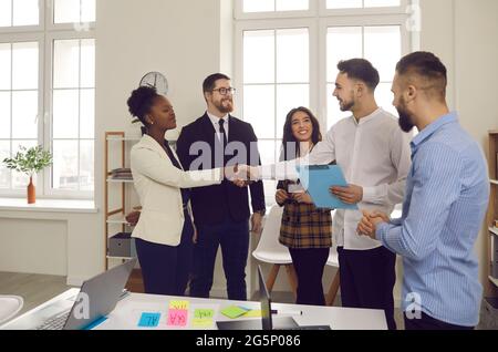 Business team colleagues shaking hands while working in creative office Stock Photo