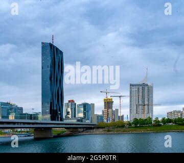 VIENNA, AUSTRIA - MAY 05, 2021: Danube river with ships and the DC tower in the background in Wien, Vienna, Austria on a cloudy day. Stock Photo