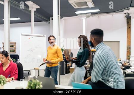 Boomer business man writing in a whiteboard during a meeting in the office. Stock Photo
