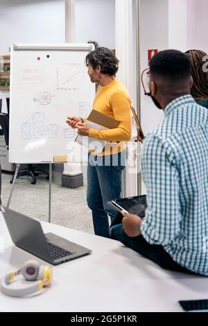 Boomer business man writing in a whiteboard during a meeting in the office. Stock Photo