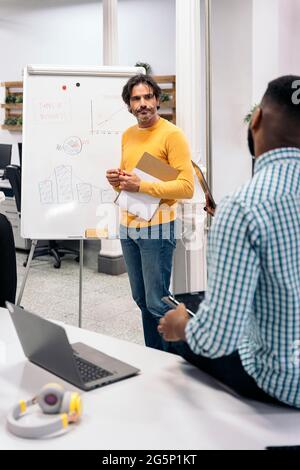 Boomer business man writing in a whiteboard during a meeting in the office. Stock Photo