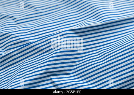 Classic blue and white striped fabric texture. Crumpled bright colored cotton background. Selective focus. Closeup view Stock Photo